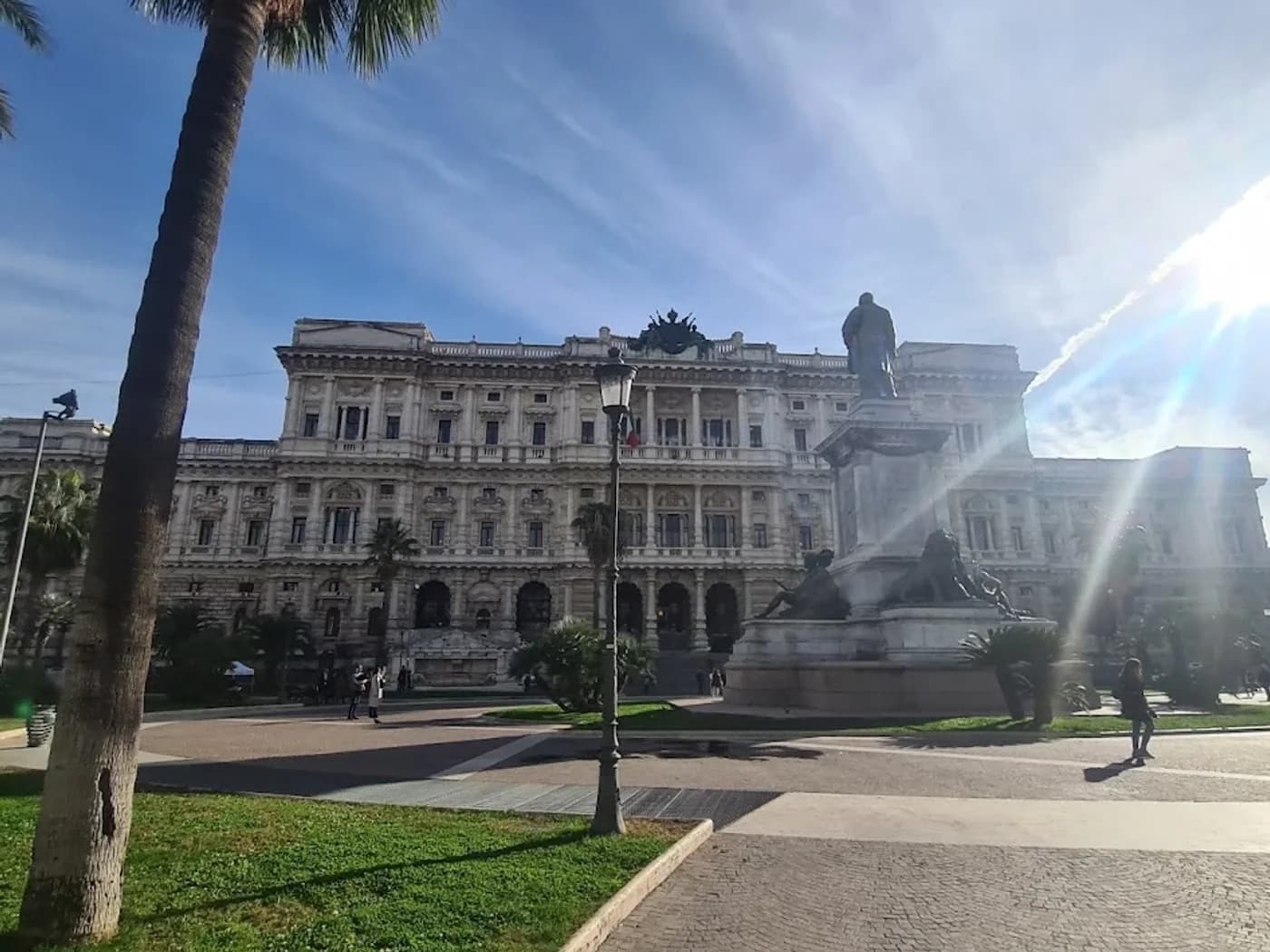 Il Palazzo di Giustizia a Piazza Cavour, con una palma e un monumento in primo piano