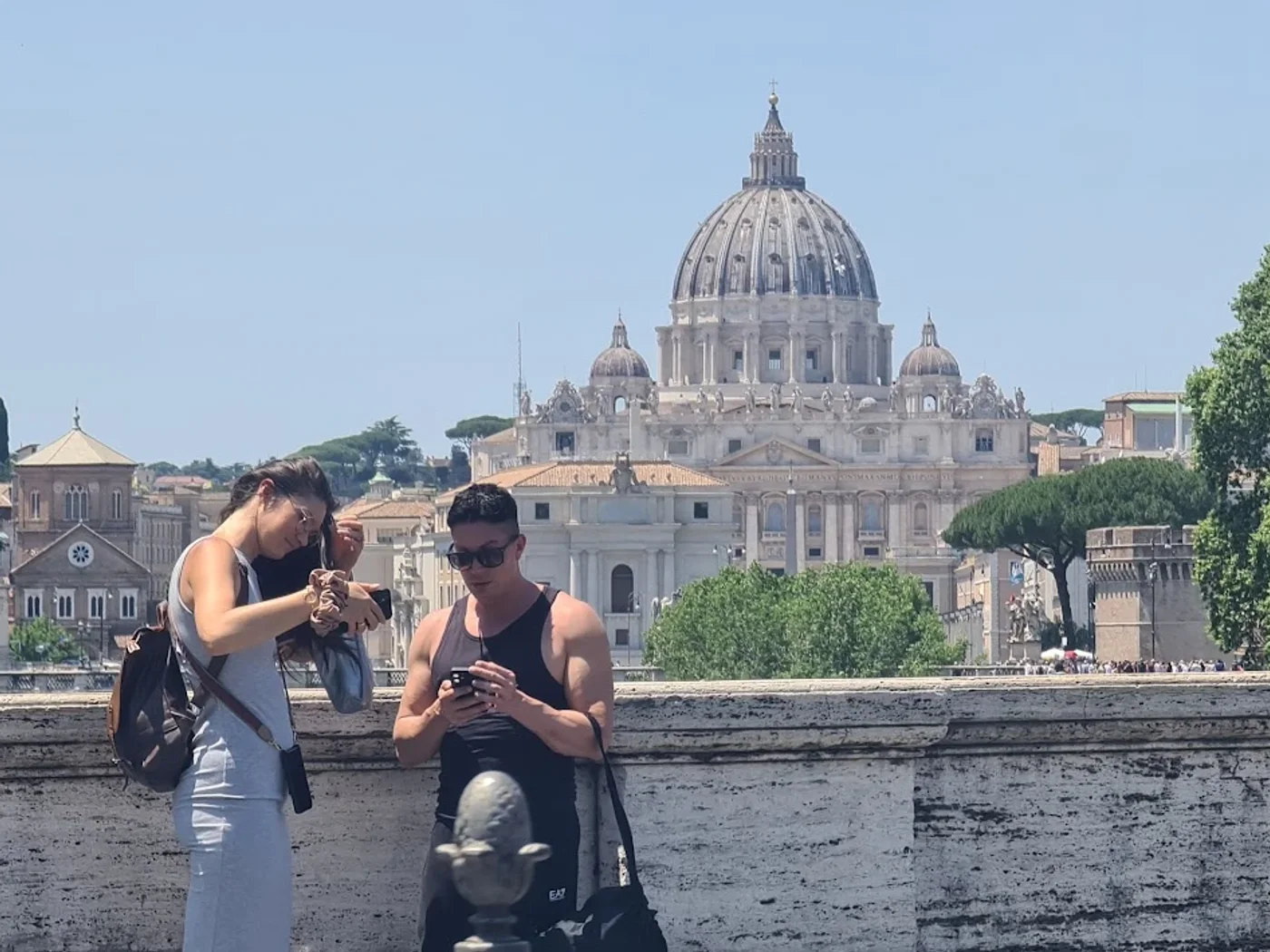 Due turisti fotografano la cupola di San Pietro da un ponte sul Tevere