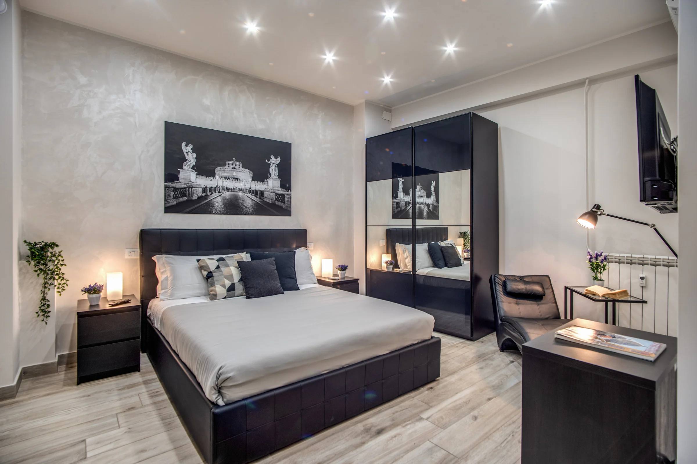 Camera matrimoniale di Tacito 23 con letto, illuminazione calda e dettagli contemporanei